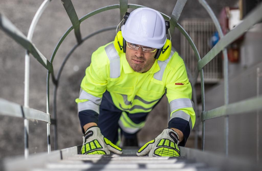 man climbing ladder in workwear high viz hard hat safety goggles