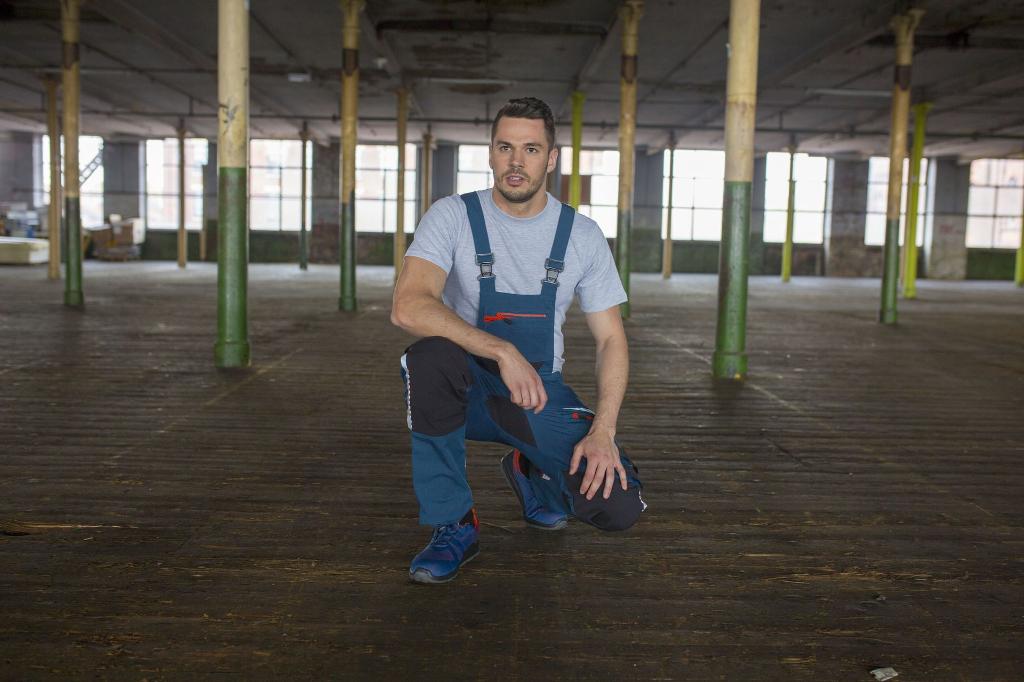 man kneeling down in workwear uniform in building site
