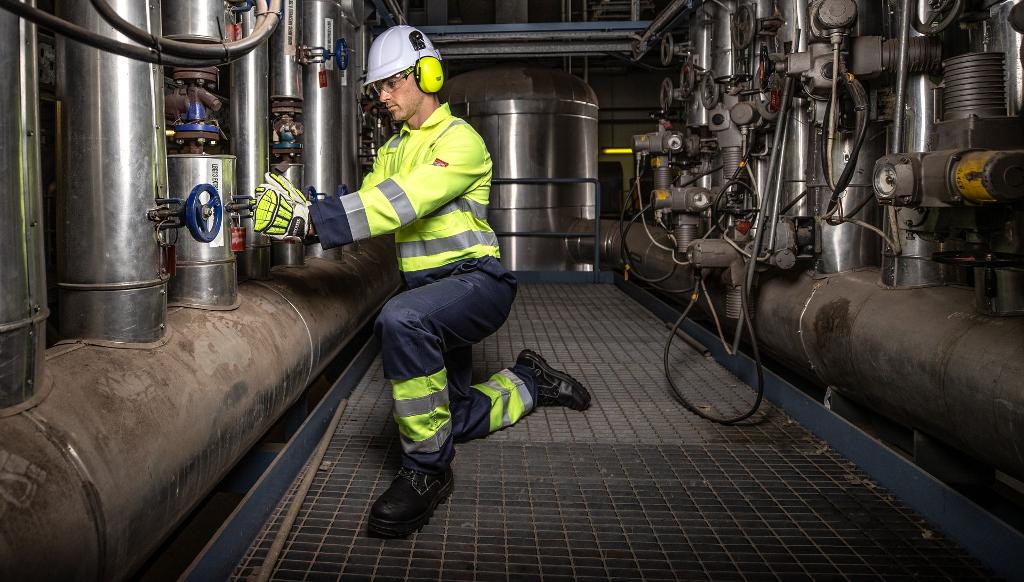 man turning valve in high vis safety uniform