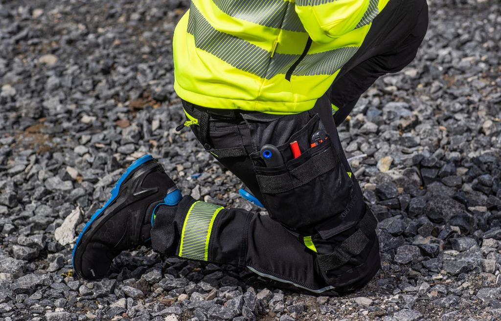 man kneeling in cargo pants with utility pocket workwear