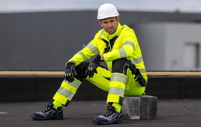 man in hi vis jacket and trousers on building site wearing workwear