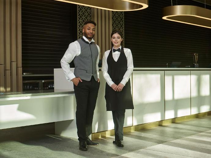 staff in hospitality uniform standing in hotel lobby